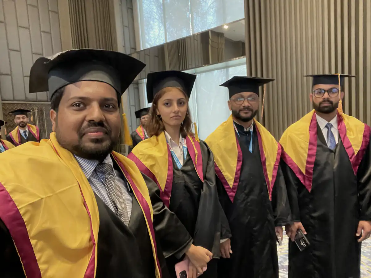 Abdul Mannan Zinnat in a graduation cap and gown with fellow graduates in Nepal, 2025