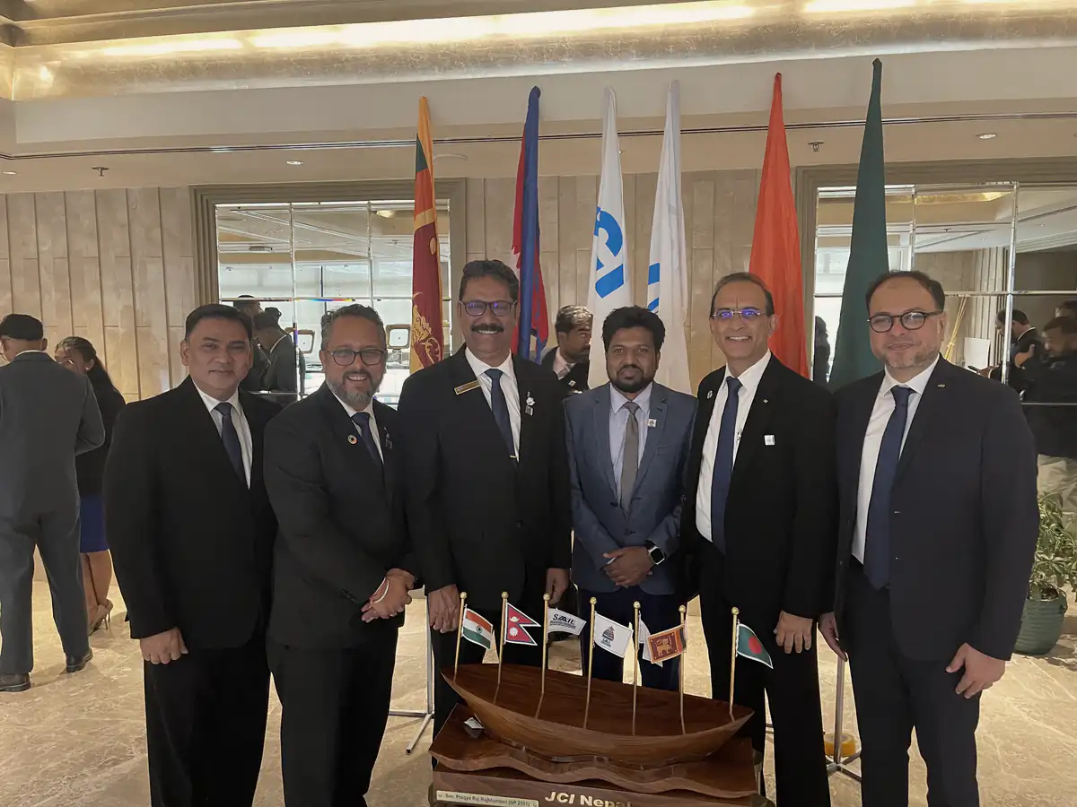Abdul Mannan Zinnat with JCI leaders in a hotel lobby, national flags behind them
