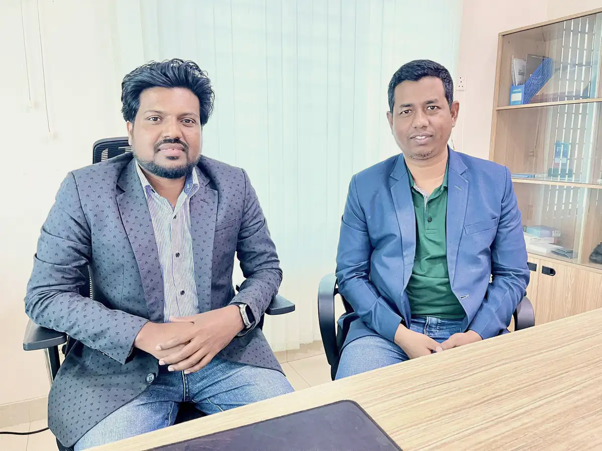Abdul Mannan Zinnat seated beside a guest in the office