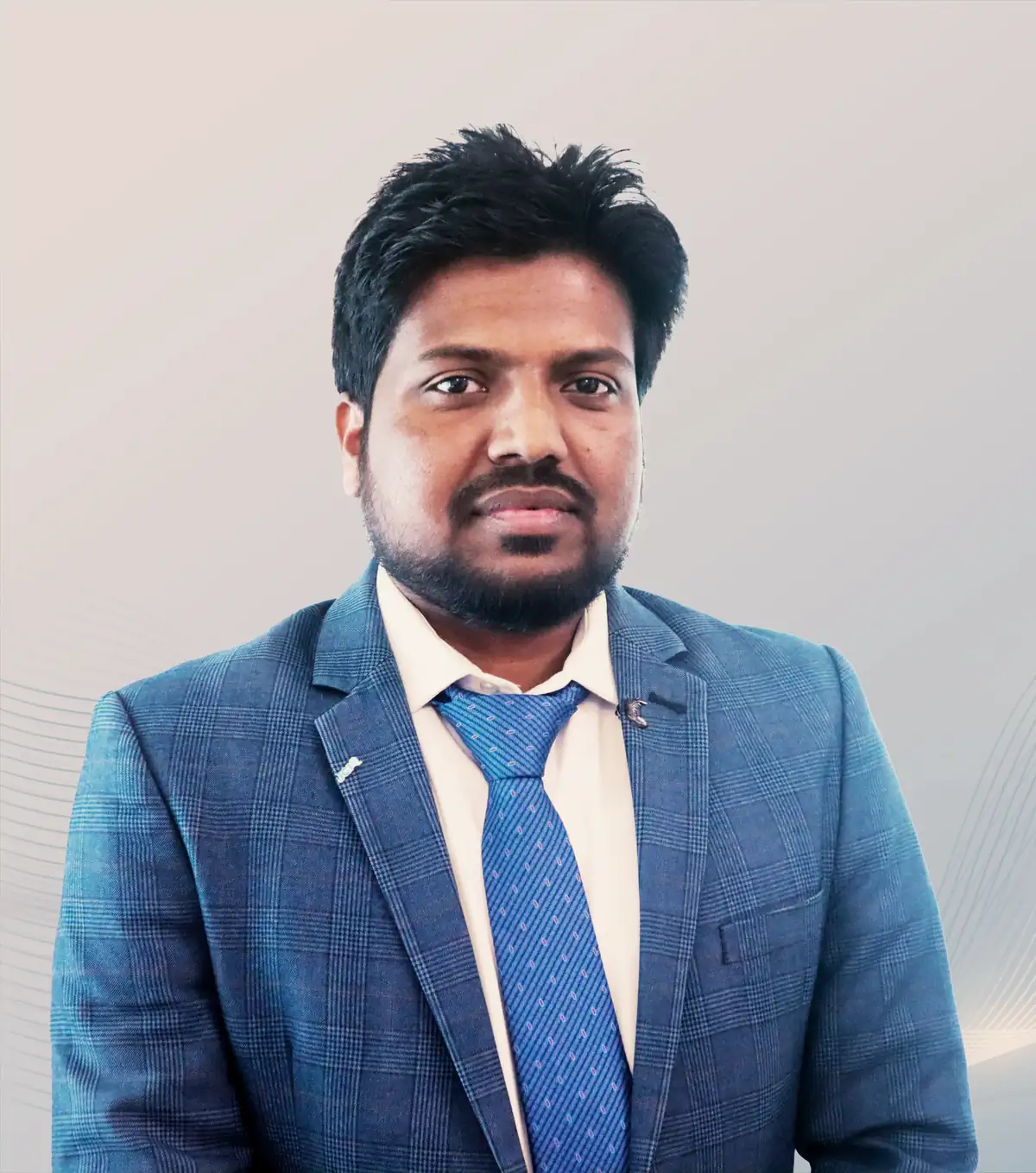 Portrait of Abdul Mannan Zinnat, Founder & CEO of SpaGreen Creative, in a blue checked blazer and blue tie