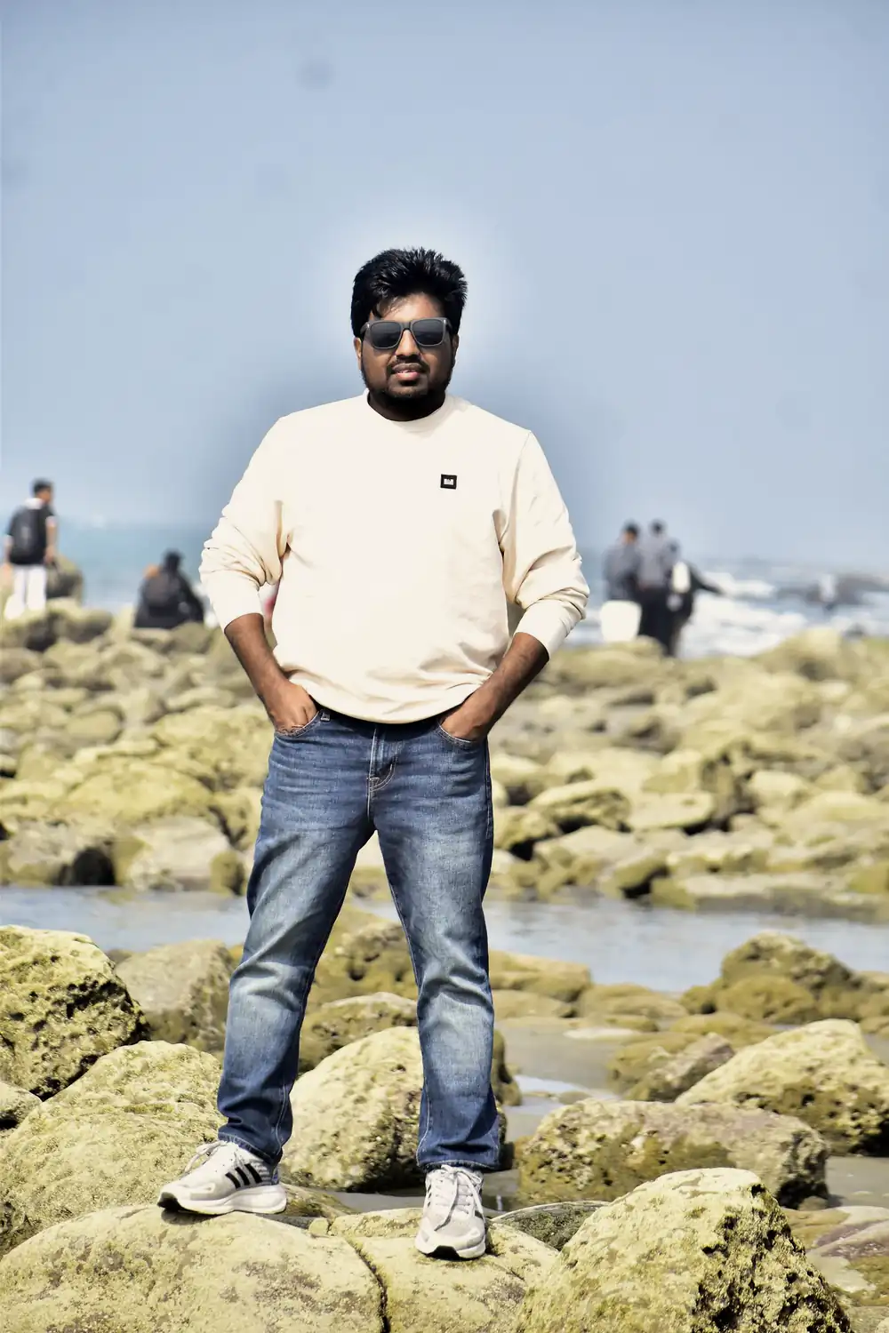 Abdul Mannan Zinnat standing on rocks at the sea beach